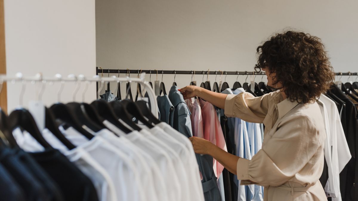 古着 初心者｜ハンガーラックから服を1着手に取って選んでいる様子